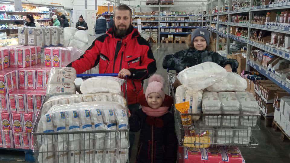 Ukrainian Family With Grocery Carts Full Of Emergency Food Supplies